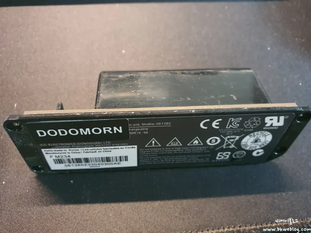 DODOMORN compatible replacement battery for Bose SoundLink Mini 1, model 061385 Caption: The "compatible" battery — scratched casing, third-party label, same footprint.