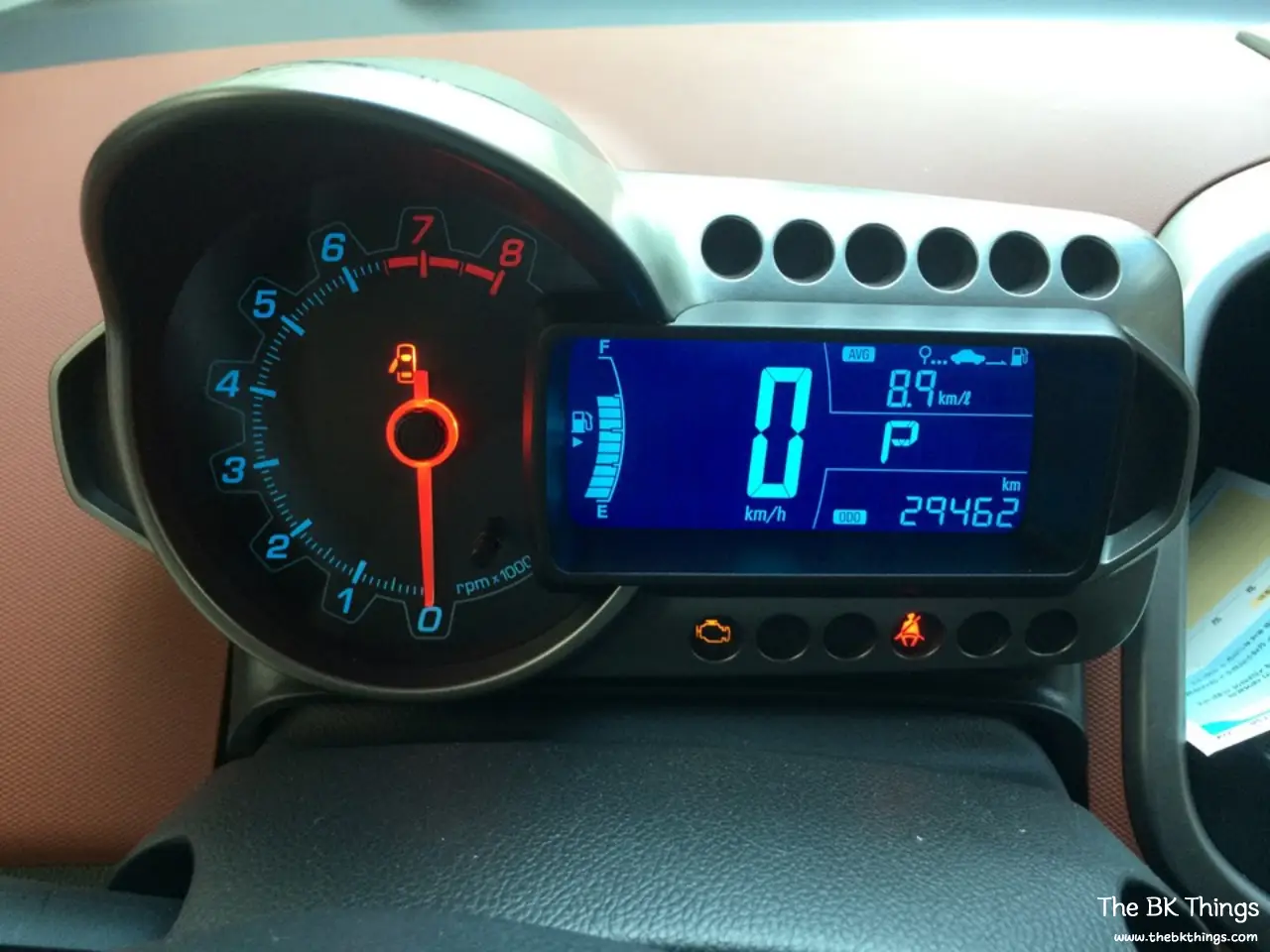 Chevrolet Aveo / Sonic motorcycle-style instrument cluster showing 29,462 km and 8.9 km/L average fuel economy